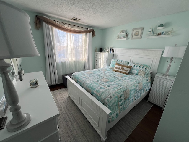 bedroom with dark wood-type flooring and a textured ceiling