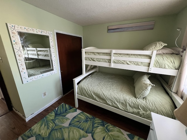 bedroom featuring dark wood-type flooring and a textured ceiling