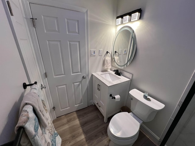 bathroom featuring hardwood / wood-style flooring, toilet, and vanity