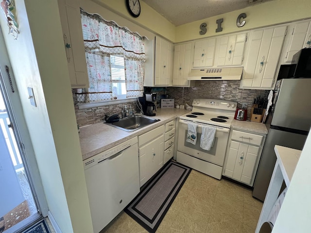 kitchen featuring white cabinetry, sink, tasteful backsplash, and white appliances