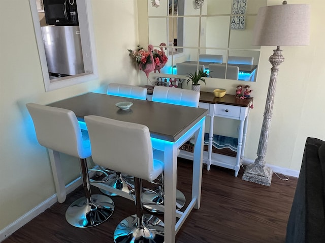 dining space with dark hardwood / wood-style flooring