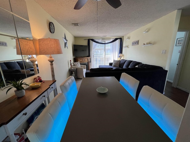 dining area with ceiling fan and a textured ceiling