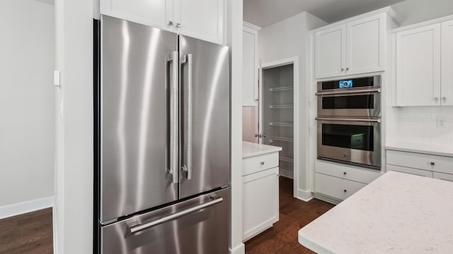 845 Broadway Unit 1, West Cape May, NJ 08204 - kitchen featuring stainless steel appliances, dark wood-style floors, white cabinetry, decorative backsplash, and baseboards