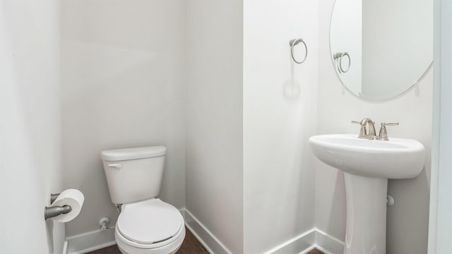 845 Broadway Unit 1, West Cape May, NJ 08204 - half bathroom with toilet, baseboards, a sink, and wood finished floors