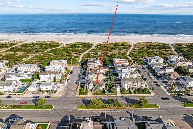 drone / aerial view featuring a water view and a beach view