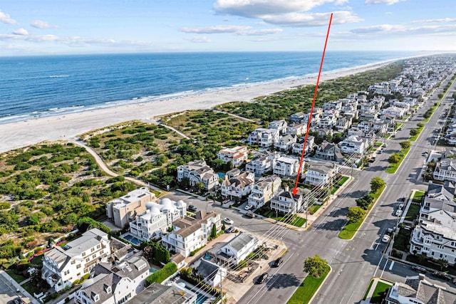 drone / aerial view with a water view and a beach view