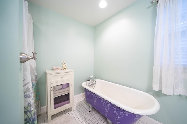 full bath featuring baseboards, a soaking tub, and tile patterned floors