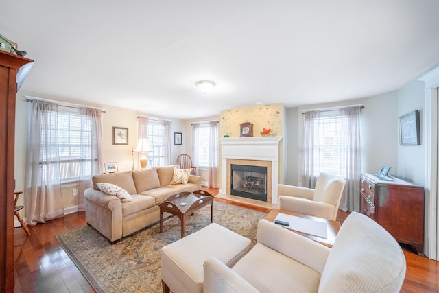 living room featuring a healthy amount of sunlight, a fireplace with flush hearth, and wood finished floors