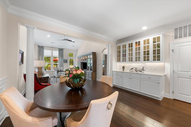 dining room with dark hardwood / wood-style flooring, ornate columns, ceiling fan, crown molding, and lofted ceiling