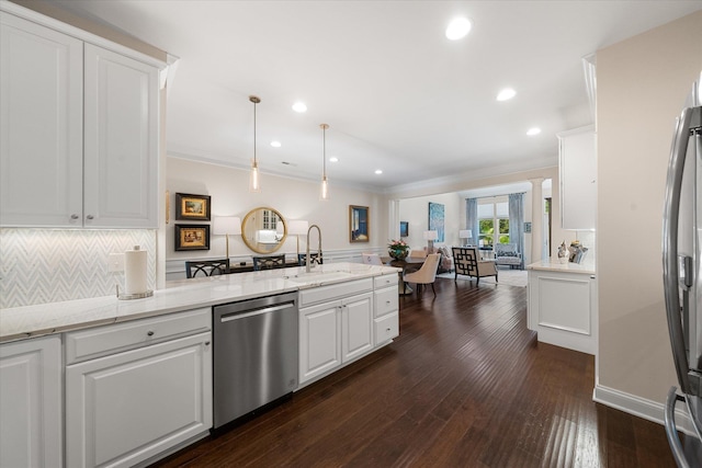 kitchen with white cabinets, sink, hanging light fixtures, ornamental molding, and stainless steel appliances