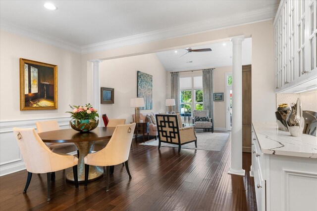 dining space with ceiling fan, ornamental molding, dark wood-type flooring, and ornate columns