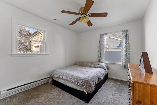 carpeted bedroom featuring a baseboard radiator, visible vents, a ceiling fan, and multiple windows