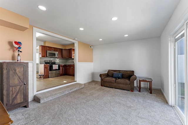 living area featuring recessed lighting, light colored carpet, and a healthy amount of sunlight