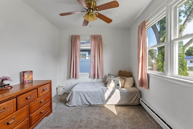 carpeted bedroom featuring a baseboard radiator, ceiling fan, and multiple windows