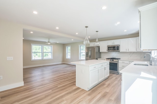 80 W Rising Sun Dr, Ocean View, NJ 08230 - kitchen featuring appliances with stainless steel finishes, a kitchen island, light wood finished floors, white cabinetry, and decorative backsplash