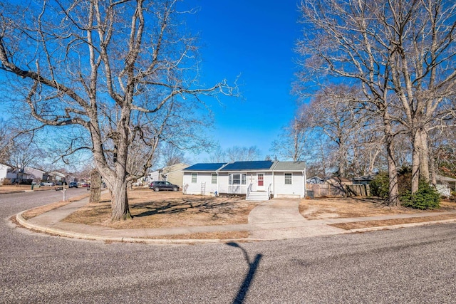 ranch-style home with entry steps, driveway, and fence