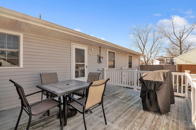 wooden terrace featuring outdoor dining space and fence