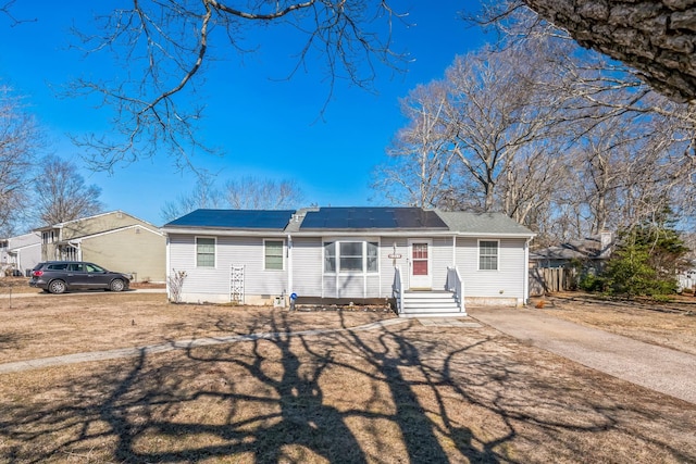 ranch-style home with roof mounted solar panels and fence