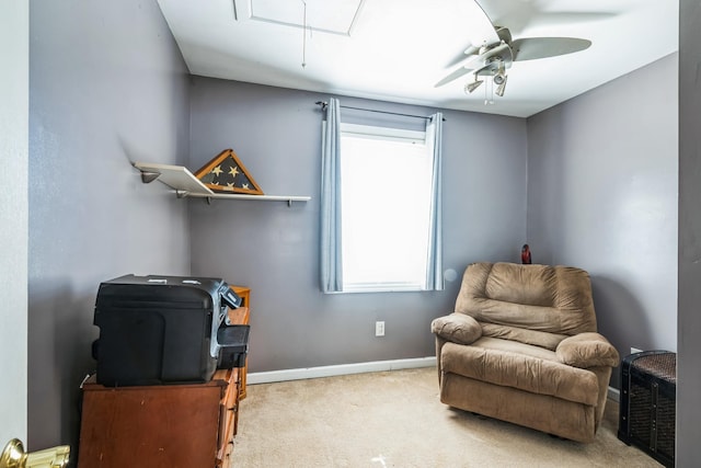 sitting room featuring carpet floors, attic access, baseboards, and a ceiling fan