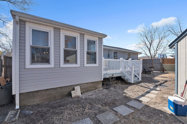 view of side of home with fence and a deck