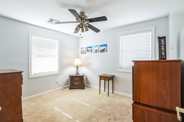 living area with visible vents, carpet floors, a ceiling fan, and baseboards