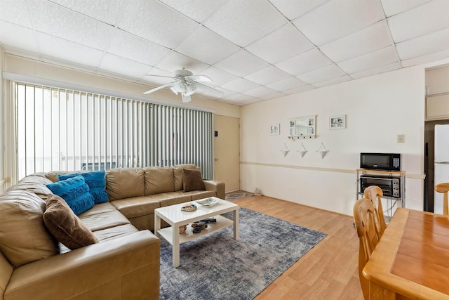 living room with a paneled ceiling, ceiling fan, and wood-type flooring