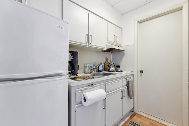 kitchen with sink, white cabinets, and white refrigerator