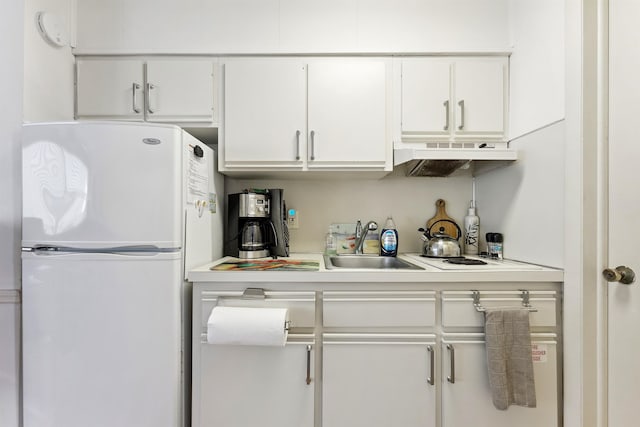 kitchen with white cabinetry, sink, exhaust hood, and white refrigerator