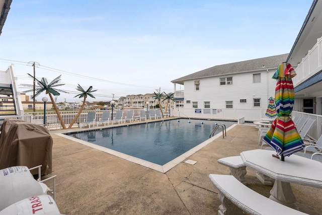 view of pool with a grill and a patio