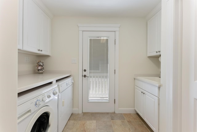 clothes washing area with sink, cabinets, and independent washer and dryer