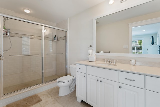 bathroom featuring tile patterned flooring, vanity, toilet, and a shower with door