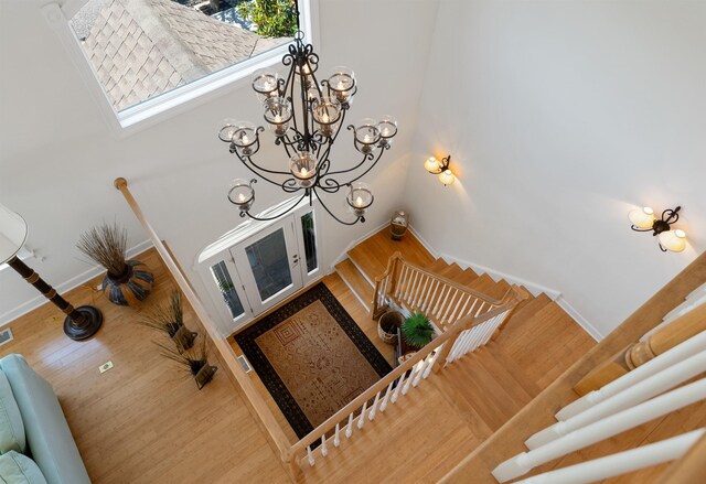 staircase featuring hardwood / wood-style flooring and an inviting chandelier