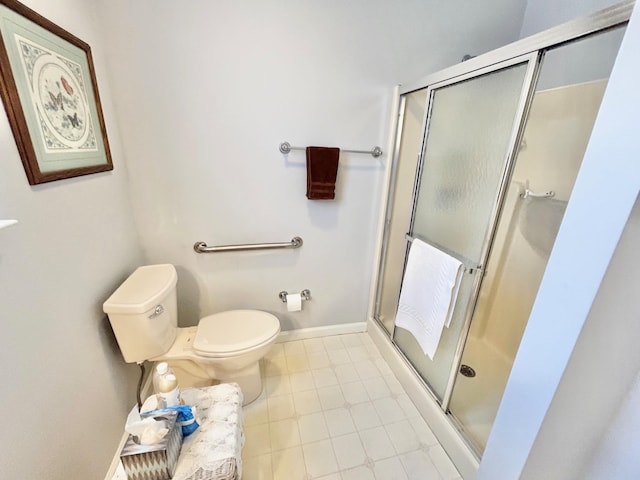 full bathroom featuring baseboards, toilet, and a shower stall