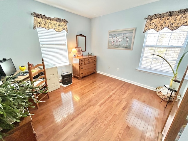 living area featuring light wood-type flooring and baseboards