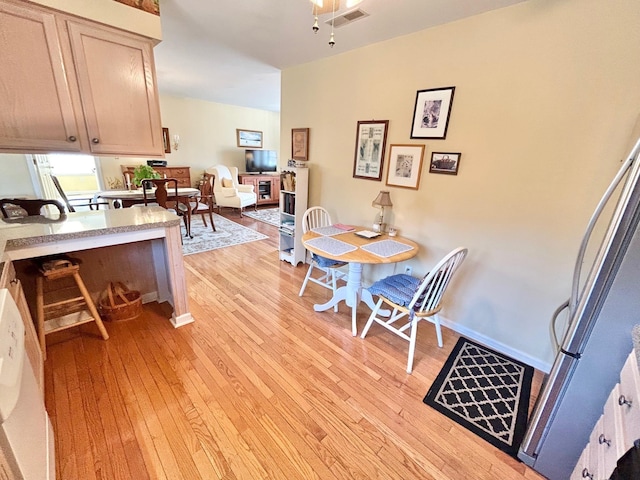 dining area with visible vents, baseboards, and light wood-style flooring