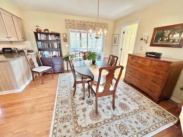 dining space with a notable chandelier and light wood-type flooring