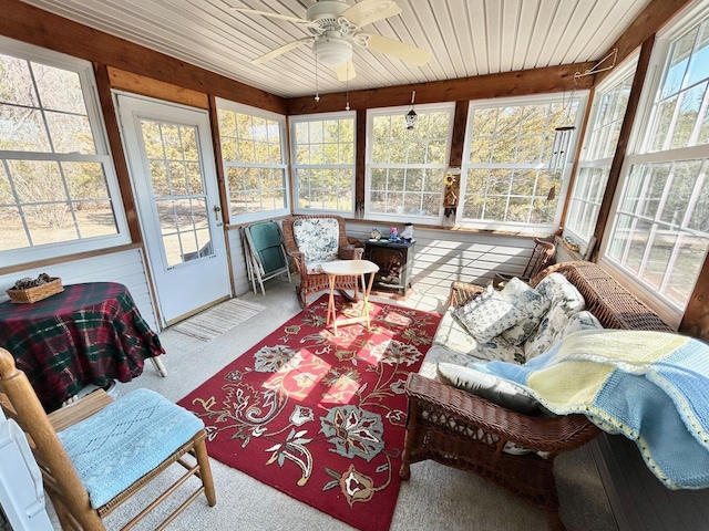 sunroom / solarium featuring plenty of natural light, wood ceiling, and ceiling fan