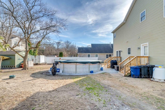 view of yard featuring a storage shed, an outbuilding, fence, and a fenced in pool