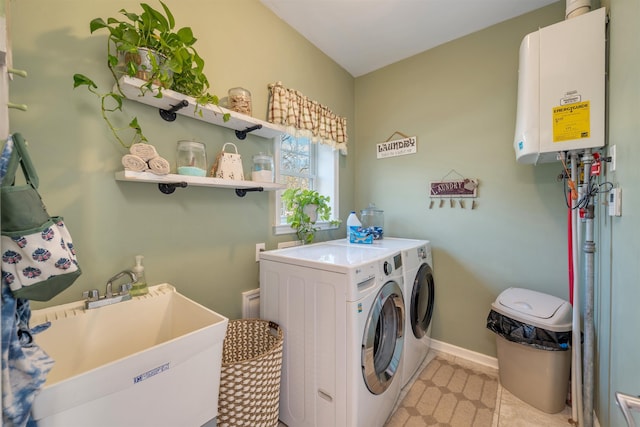 laundry room with tankless water heater, a sink, laundry area, independent washer and dryer, and baseboards