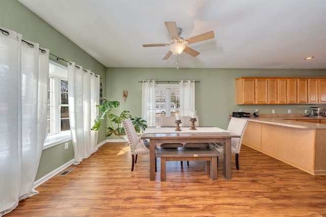 dining space featuring light wood-type flooring, visible vents, ceiling fan, and baseboards