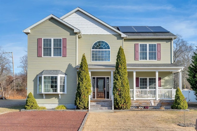 view of front facade featuring covered porch and solar panels