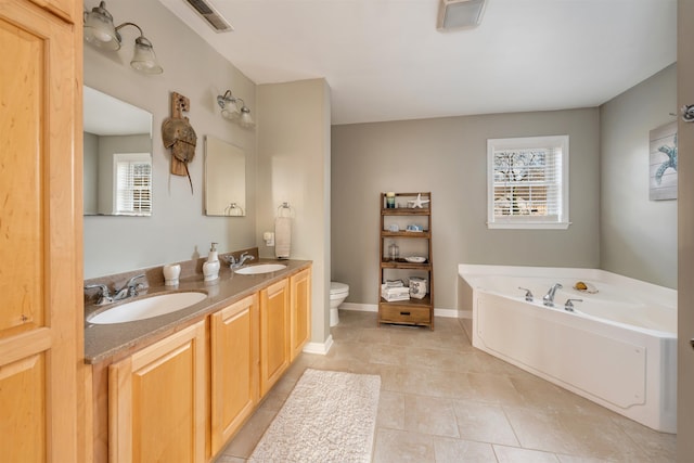 bathroom featuring visible vents, a sink, toilet, and a bath