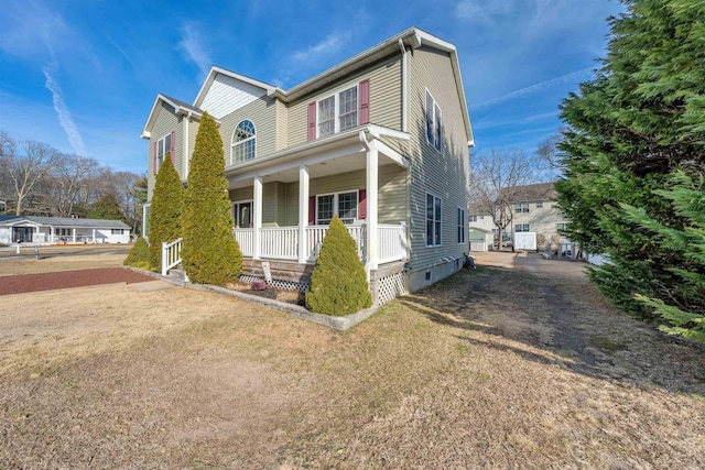 view of front of home featuring crawl space, covered porch, driveway, and a front lawn