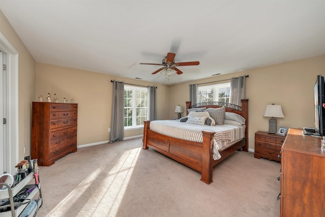 bedroom with light carpet, ceiling fan, and baseboards