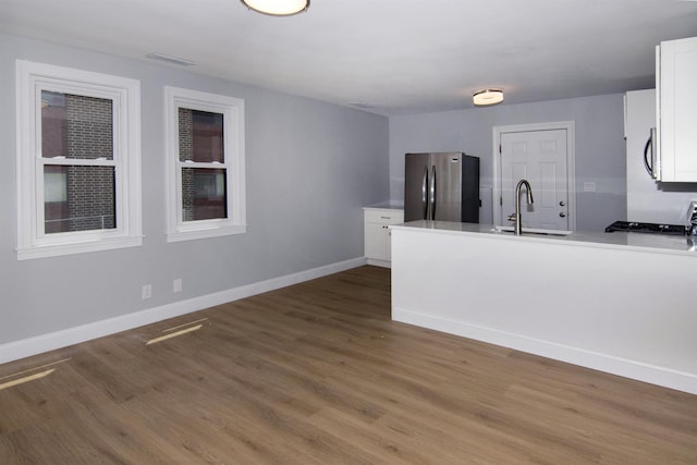 30 Pinetree Dr, Villas, NJ 08251 - kitchen with stainless steel appliances, a sink, white cabinets, a peninsula, and wood finished floors