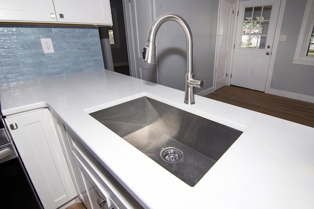 30 Pinetree Dr, Villas, NJ 08251 - kitchen view of a sink, decorative backsplash, light countertops, white cabinets, and baseboards
