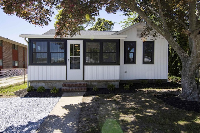 30 Pinetree Dr, Villas, NJ 08251 - view of front of house featuring a sunroom, roof with shingles, and fence