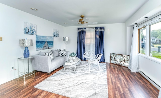 living room with dark hardwood / wood-style floors, ceiling fan, and a baseboard heating unit