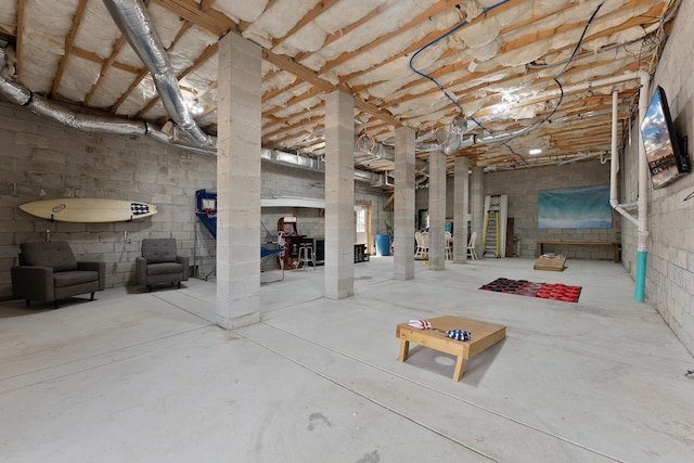 unfinished basement featuring concrete block wall