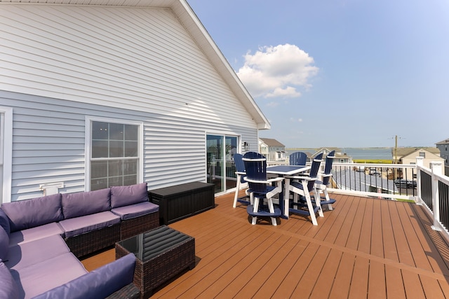 wooden deck with a water view and outdoor lounge area